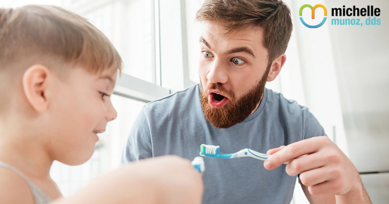 Dad and son having fun brushing their teeth together